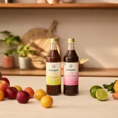 Zwei Flaschen Cellagon Aurum stehen neben frischem Obst und Gemüse. Ideal, um Eisen und Vitamin D zusammen einzunehmen für Vitalität.